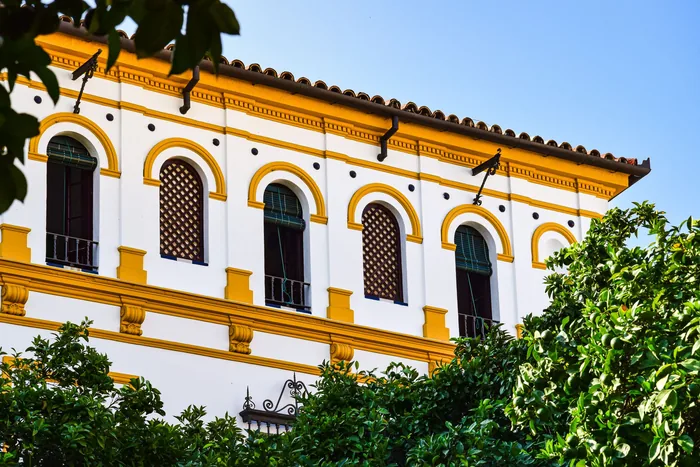 Arched windows on a white and yellow wall in Spain, for capital gains tax Spain guide