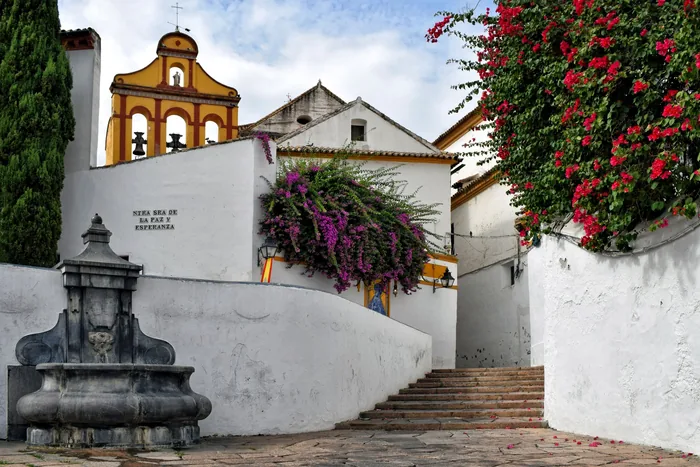 Concrete steps leading to church with yellow bell tower, Spain