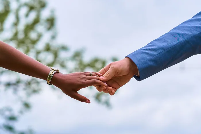 Close-up of a bride and groom holding hands in Spain