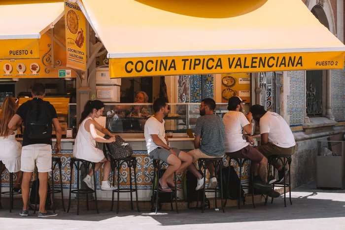 People sitting at the counter of a street cafe in Spain