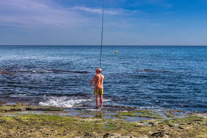 Man fishing from the rocks on the Torrevieja coastline